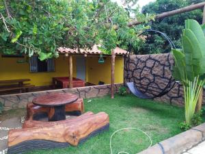 een tafel en een houten stronk in een tuin bij Rancho Andrade in Três Marias