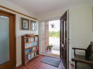 a living room with a book shelf and a door at Plum Hill Studio in Oswestry