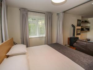 a bedroom with a large white bed and a window at Plum Hill Studio in Oswestry