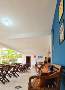 Habitación con sillas de madera y pared azul. en Pousada Paraty Graziela en Parati
