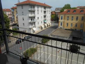einen Balkon mit Blick auf eine Straße und Gebäude in der Unterkunft allo Sferisterio, Cuneo in Cuneo
