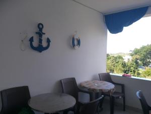 two tables and chairs in a room with a window at Mica apartmani in Sutomore