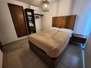 a bedroom with a bed and a dresser in a room at Amplio departamento con alberca in Guadalajara