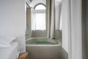 ein Badezimmer mit Badewanne und Fenster in der Unterkunft Torre Subrosa, vasca in camera cromoterapia in Viterbo + 34 Fotos
