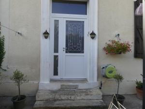 una puerta blanca de una casa con una planta en la maison du lac, en Aubin