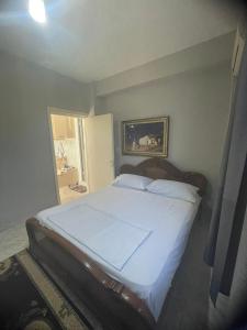 a bedroom with a large bed with white sheets at Flat in Tirana