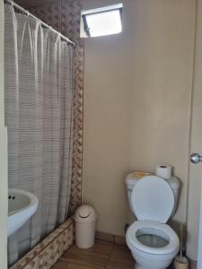 a bathroom with a toilet and a sink at Bungalows Payancas de Tato in Barranca