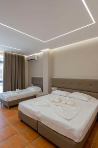 2 camas en una habitación de hotel con sábanas blancas en Hotel Miami Beach en Golem