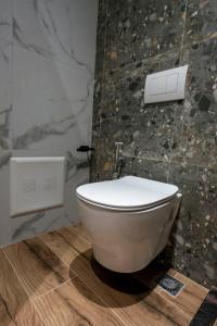 aseo blanco en un baño con pared de piedra en Hotel Miami Beach, en Golem