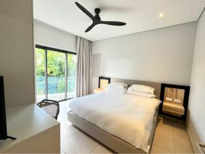 a bedroom with a bed and a ceiling fan at Black Marlin Apartments in Pereybere