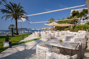 a row of tables and chairs with a view of the ocean at Hotel Torre del Mar - Ibiza in Playa d'en Bossa