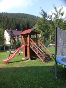 a playground with a slide in the grass at Penzion Adam - Makov in Makov