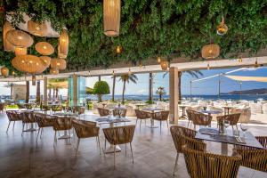 a restaurant with tables and chairs and a view of the ocean at Hotel Torre del Mar - Ibiza in Playa d'en Bossa