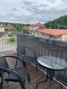 un patio con 2 sillas y una mesa en el balcón en Apartamenty i Pokoje Gracja Miedzyzdroje, en Międzyzdroje