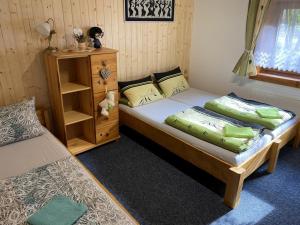 a bedroom with two twin beds and a cabinet at VILLA MARTINI in Lazy pod Makytou