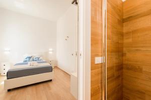 a bedroom with a bed and a walk in shower at B&B Villaggio Dei Pescatori in San Vito lo Capo