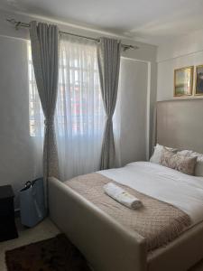 uma cama com uma toalha num quarto em Zoe Homes Oak Villa Apartment 1 and 2 Bedroom 201 em Kericho