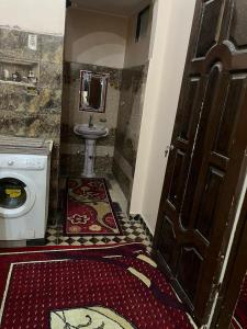 a bathroom with a toilet and a sink and a door at sun Ahmed hotel in ‘Ezbet Abu Ḥabashi