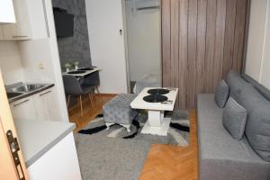 uma sala de estar com um sofá e uma mesa em Dado apartman em Kraljevo