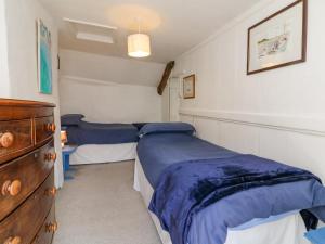 a bedroom with two beds and a dresser in it at The Retreat in Bideford