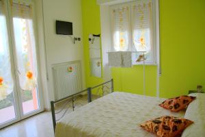 Schlafzimmer mit einem Bett mit grünen Wänden und Fenstern in der Unterkunft B&B Il Poggio in Villagrande