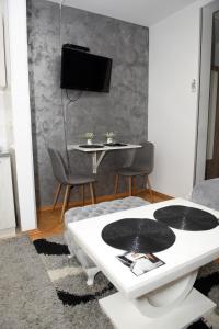 uma sala de estar com uma mesa e uma televisão em Dado apartman em Kraljevo