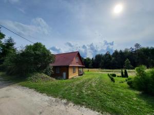 une petite maison dans un champ à côté d'un chemin de terre dans l'établissement Miejsce w lesie, 