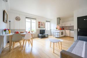 a kitchen and living room with a table and chairs at Au cœur de St Martin : Les Grenettes in Saint-Martin-de-Ré