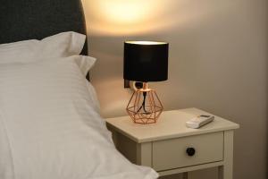 una lampada su un comodino accanto a un letto di Larisa Hospitality II - St Nicholas apartment - with Free Parking a Larisa