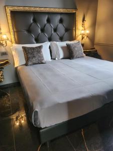 a large bed with a black headboard and pillows at Hotel Zia Piera in Chiavari