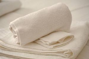 een stapel witte handdoeken zittend op een tafel bij Larisa Hospitality II - St Nicholas apartment - with Free Parking in Larisa