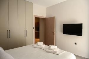 een slaapkamer met een bed met handdoeken erop bij Larisa Hospitality II - St Nicholas apartment - with Free Parking in Larisa