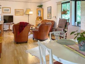 uma sala de estar com cadeiras, uma mesa e uma televisão em Holiday home KIL II em Kil