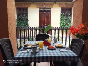 una mesa con comida y bebida en el balcón en hotel san nicolas colonial, en Barranquilla