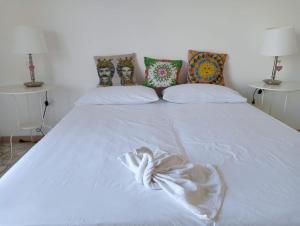 a white bed with a white dress on it at A Casa Di Alex in Catania