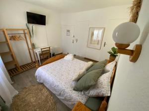 a small bedroom with a bed and a chair at Os-thel, Chambres à louer in Tautavel