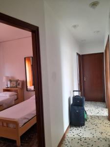 une chambre avec un lit et une valise à l'étage dans l'établissement A Casa Di Alex, à Catane