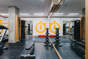 un gimnasio con equipo cardiovascular y un cartel en la pared en Le Dauphin Montréal Centre-Ville, en Montreal