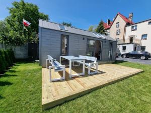 a tiny house with a table and chairs on a deck at Tiny House Jastarnia in Jastarnia