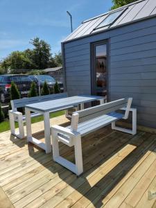 a picnic table and bench on the deck of a tiny house at Tiny House Jastarnia in Jastarnia