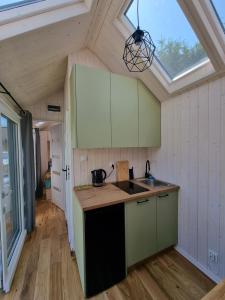 a kitchen with green cabinets and a skylight at Tiny House Jastarnia in Jastarnia
