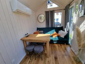 a tiny house with a table and stools and a couch at Tiny House Jastarnia in Jastarnia +2 photos