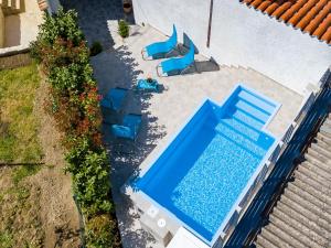 una vista aérea de una piscina con sillas azules en Villa Carmen, en Pula