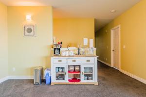 a kitchen with yellow walls and a white cabinet at Cozy one bedroom with private bathroom in Kelowna in Kelowna