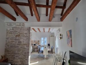 una sala de estar con una pared de piedra y vigas de madera. en Villa Carmen, en Pula