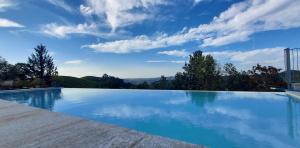 a large swimming pool with a blue sky at Casa La Vedetta in Barbaresco