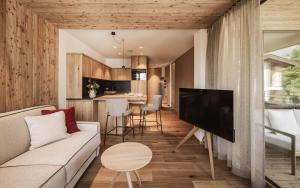 a living room with a couch and a tv and a kitchen at Milla Apartments in Bressanone +45 photos