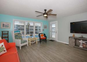 a living room with a couch and a flat screen tv at Sea Oats B106 by ALBVR - Great renovation and tons of space in this 2BR 2BA condo - Outdoor Pools, Pier, and Dedicated Beach Access in Gulf Shores