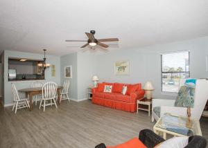 een woonkamer met een rode bank en een tafel bij Sea Oats B106 by ALBVR - Great renovation and tons of space in this 2BR 2BA condo - Outdoor Pools, Pier, and Dedicated Beach Access in Gulf Shores