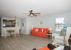 a living room with a red couch and a table at Sea Oats B106 by ALBVR - Great renovation and tons of space in this 2BR 2BA condo - Outdoor Pools, Pier, and Dedicated Beach Access in Gulf Shores